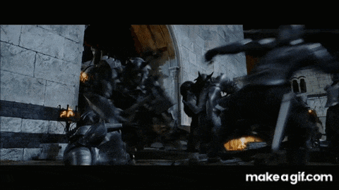 a group of soldiers are fighting each other in front of a castle .