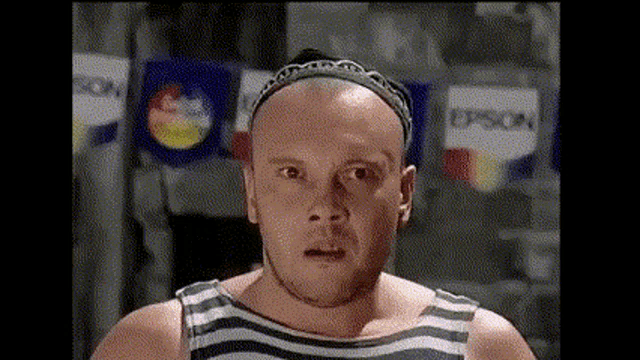 a bald man wearing a headband stands in front of a wall with epson signs on it