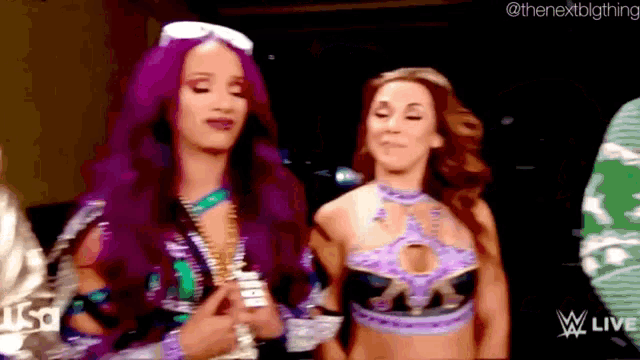 a couple of women standing next to each other with a watermark that says wwe live