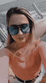 a woman wearing sunglasses is taking a picture of herself