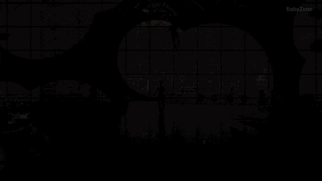 a woman is standing in front of a large window with the word babylon on the bottom right
