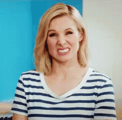 a woman wearing a striped shirt is making a funny face