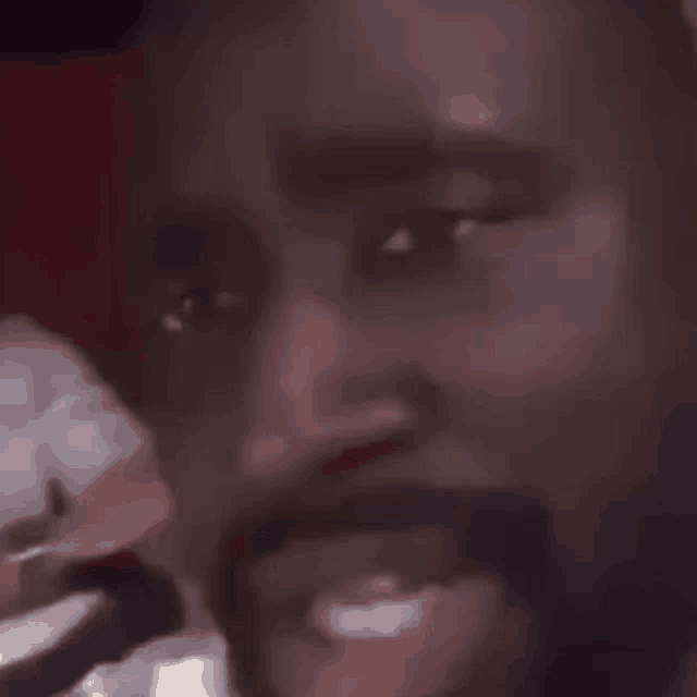 a close up of a man 's face with a beard and mustache smiling .