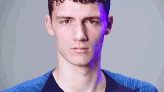 a close up of a man 's face with purple lighting