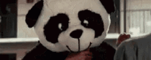 a person wearing a panda bear costume is holding a bloody hand .
