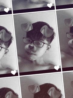 a black and white photo of a boy with dog ears on his face