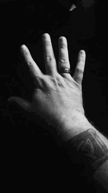 a man 's hand with a ring on his finger