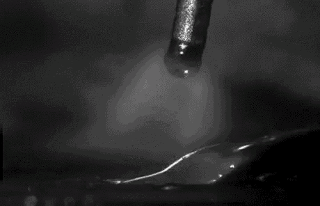 a black and white photo of a flame coming out of a bottle .
