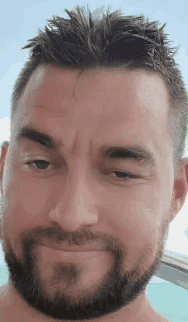 a close up of a man 's face with a beard and hair