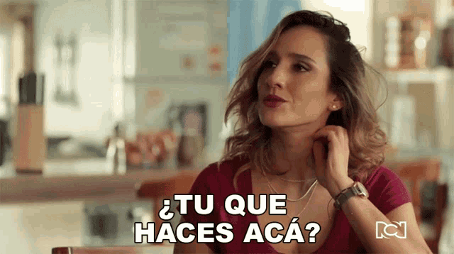 a woman sitting at a table with the words tu que haces aca
