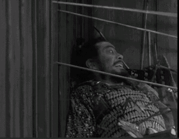 a black and white photo of a man tied up with rope