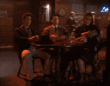 three people sit at a table in front of a sign that says ' lo ' on it