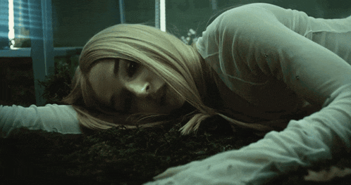 a woman in a white shirt is laying on the floor