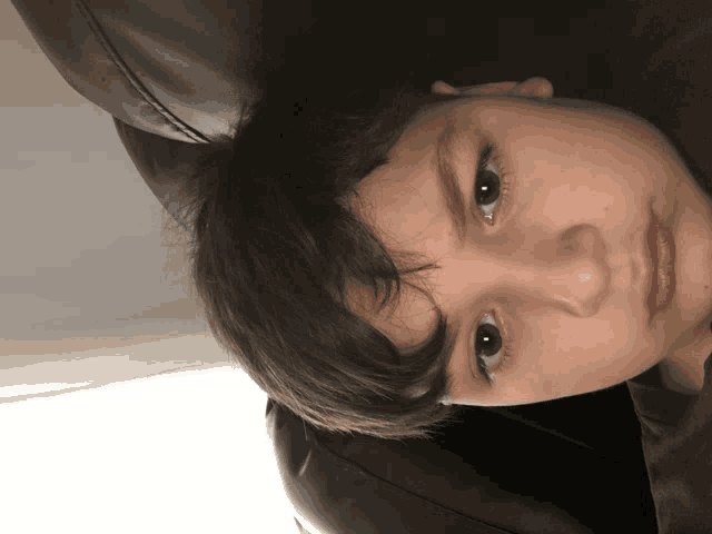 a close up of a young boy 's face with a piercing in his nose