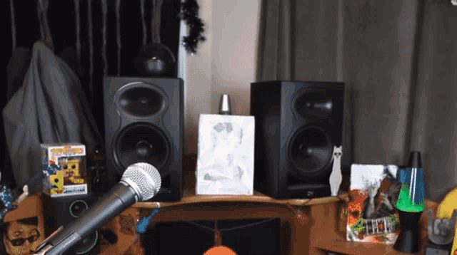 a microphone is sitting on a desk with speakers and a box that says funko pop on it
