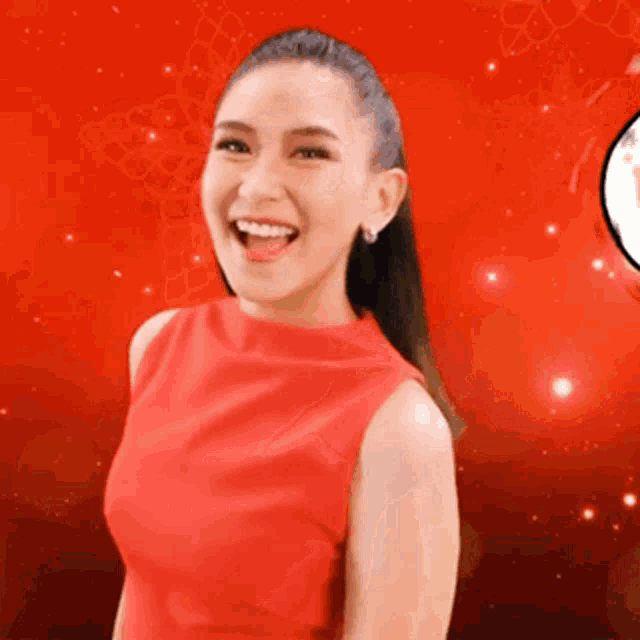 a woman in a red dress is smiling and looking at the camera
