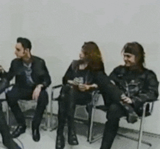 three people are sitting in chairs in a room talking to each other .