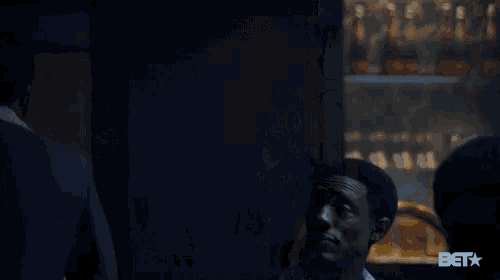a man talking to another man in a dark room with the word bet on the bottom