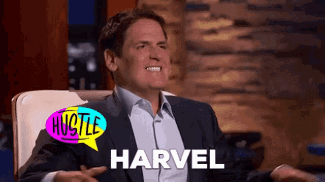 a man in a suit is sitting in a chair with a speech bubble that says hustle harvel on it .