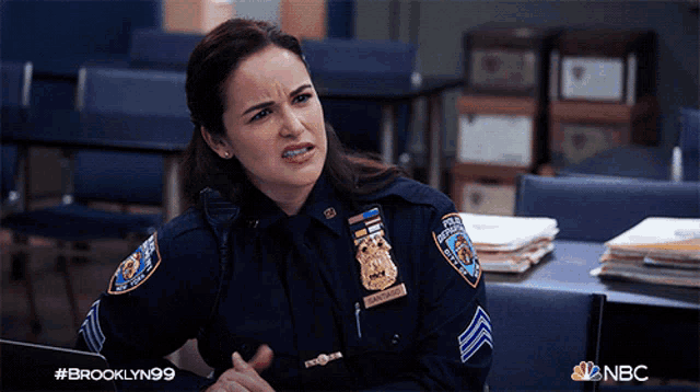 a woman in a police uniform with a badge that says brooklyn 99