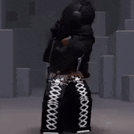 a person wearing black pants with white lace up sides is standing in a room with boxes .