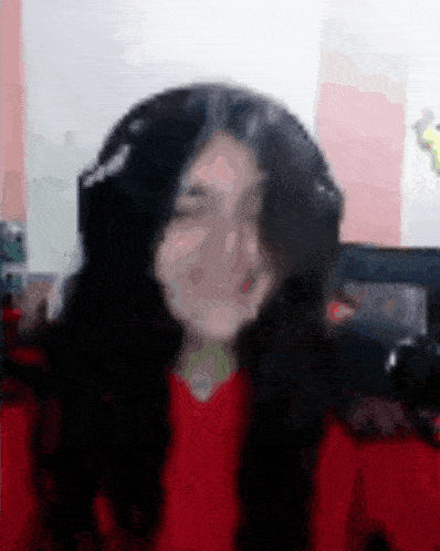 a girl wearing headphones and a red shirt is making a funny face .