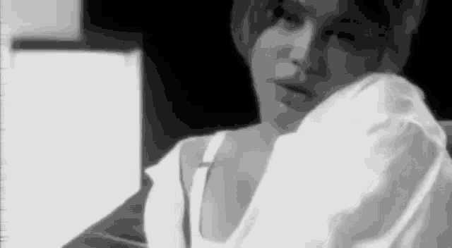 a woman is sitting on a couch in a black and white photo .