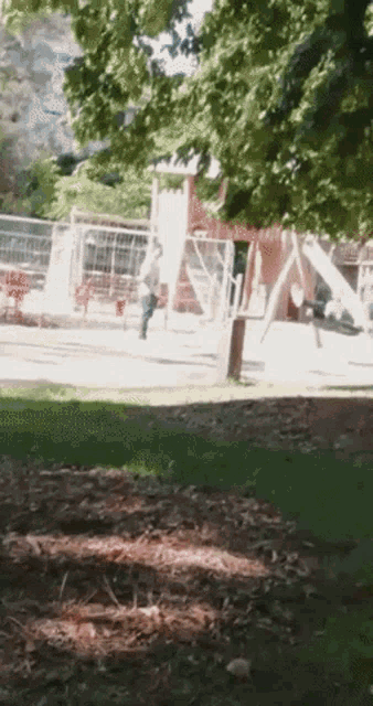 a blurry picture of a playground with a slide and swings
