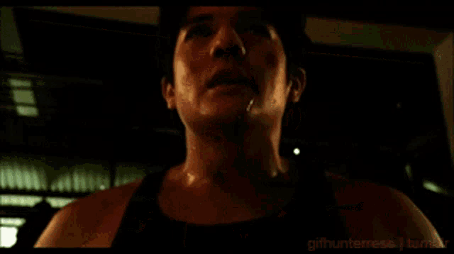 a man in a black tank top is standing in a dark room with the words gifhunteress tumblr on the bottom