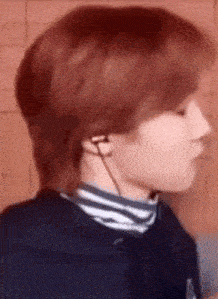 a close up of a person 's face wearing headphones and a striped shirt .