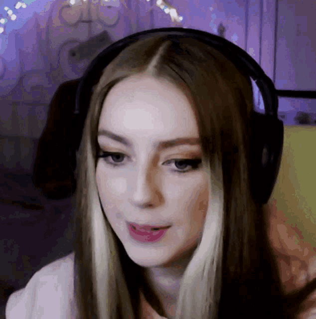 a close up of a woman wearing headphones and looking at the camera