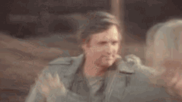 a blurry picture of a man in a military uniform standing in front of a mirror .