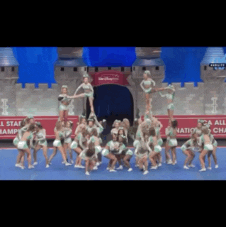 a group of cheerleaders are performing in front of a sign that says disney world