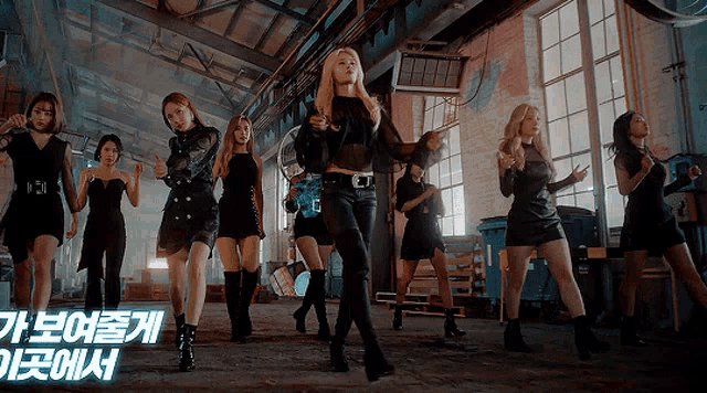 a group of women are dancing in a room with a sign that says ' korean ' on it