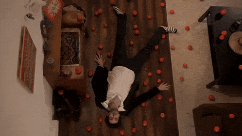 a man in a suit is upside down on the floor