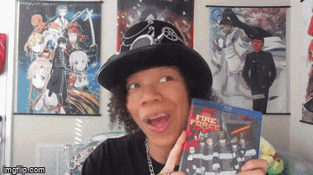 a man in a hat is holding a blu-ray of fire force