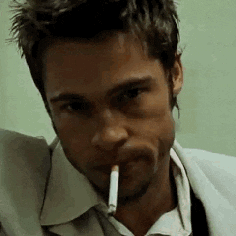 a man is smoking a cigarette in his mouth in a close up .
