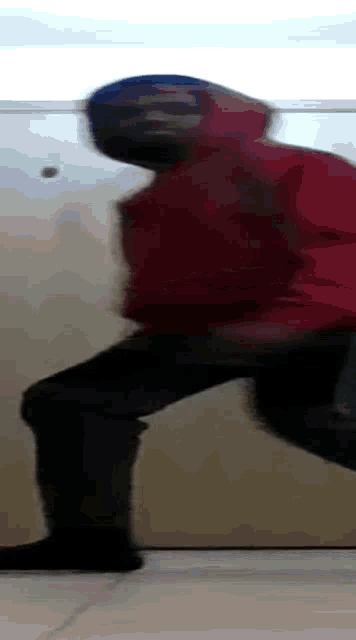 a blurry picture of a person wearing a red jacket and black pants