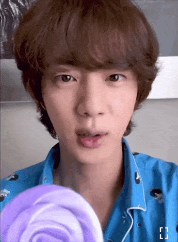a close up of a person 's face with a lollipop in the background