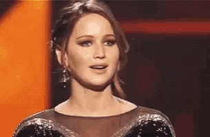 a woman in a black dress is standing in front of a stage .