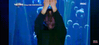 a person is standing in front of a screen with bubbles on it and their hands in the air .