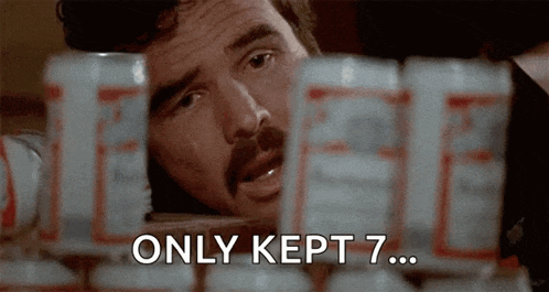 a man with a mustache is looking at budweiser cans and says only kept 7