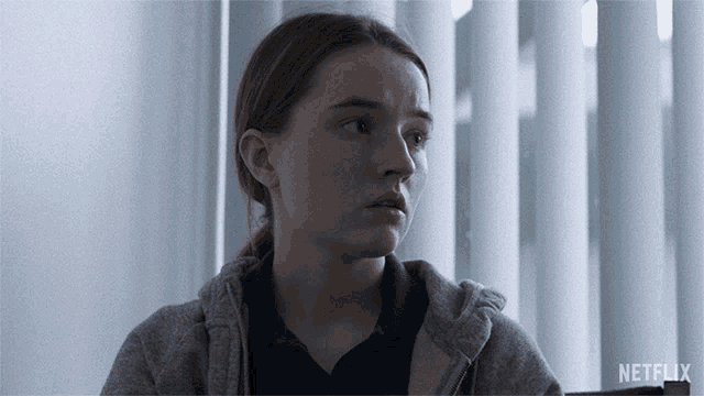 a woman sitting in front of a window with netflix written on the bottom