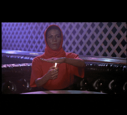 a woman in a red sweater is holding a lighter