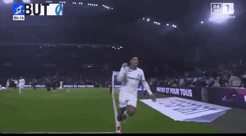a soccer player wearing a cmacg jersey celebrates his goal