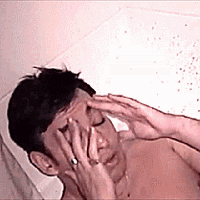a man with a ring on his finger is laying in a bathtub