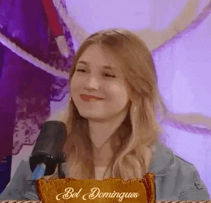 a woman is sitting in front of a microphone smiling .