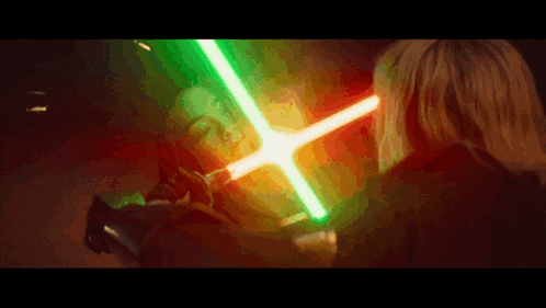 a woman is holding a green light saber in front of her face