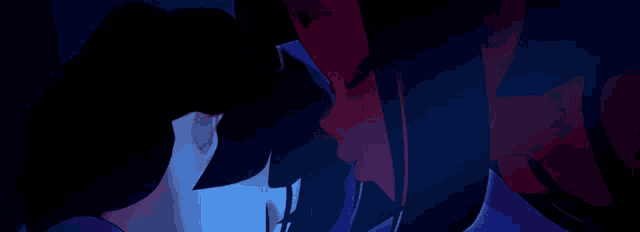 a man and a woman are looking at each other in a dark room