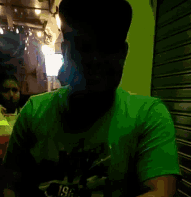 a man wearing a blue shirt with the letter n on it is smiling